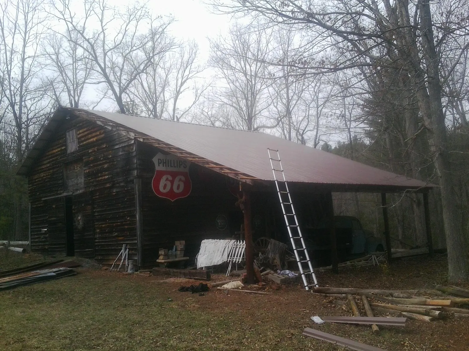 New metal roof on an open sided timber barn with a vintage sign in New Sharon