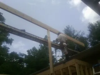 Carpenter setting a ridge beam over a new addition frame — Ice Dam Removal by Roofing Brothers in New Sharon