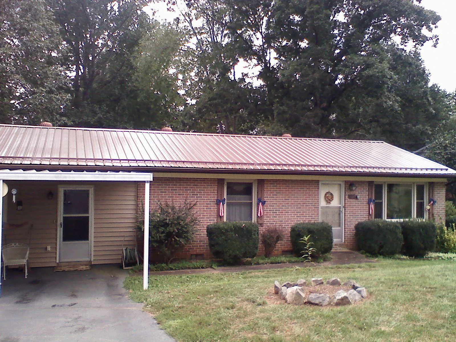 Bronze metal roof and carport on a brick ranch home — Roof Repair work by our crew in New Sharon